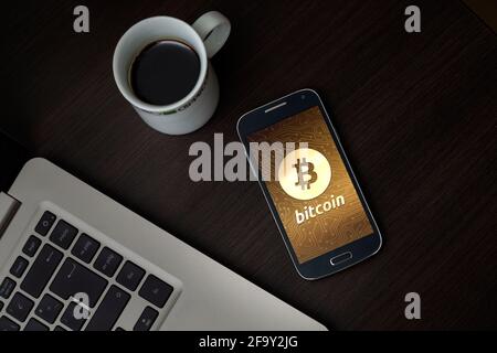 Bitcoin symbol on mobile smartphone app screen with golden circuit background. Bitcoin value grow concept. Technology, digital money. Stock Photo