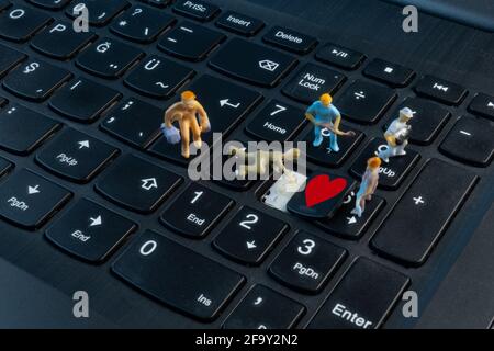 Mini Workers working on love on top of keyboard Stock Photo