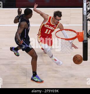 Atlanta, USA. 21st Apr, 2021. The Atlanta Hawks' Trae Young (11) drives to the basket against the Orlando Magic's Dwayne Bacon on Tuesday, April 20, 2021, at State Farm Arena in Atlanta. (Photo by Curtis Compton/Atlanta Journal-Constitution/TNS/Sipa USA) Credit: Sipa USA/Alamy Live News Stock Photo
