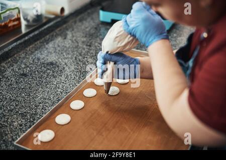 Busy pastry chef making even circles of icing Stock Photo