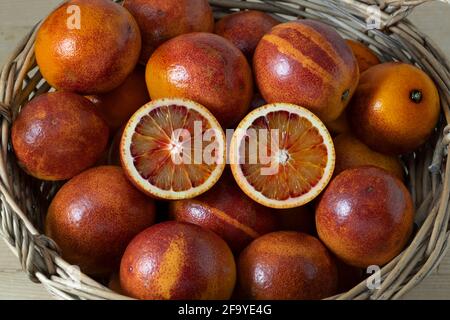 Basket with fresh red whole and halved ripe blood oranges close up Stock Photo