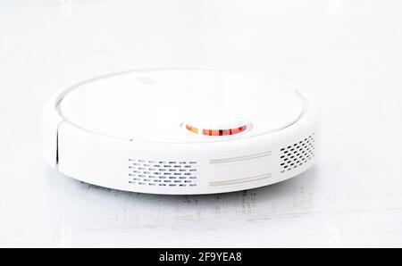 White robotic vacuum cleaner on a floor Stock Photo