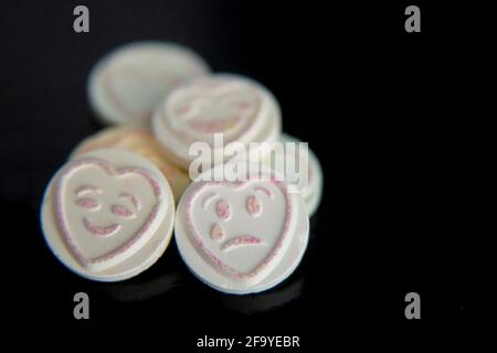 Love heart sweet emojis emoticons on black background, sad face and happy face. Focus on sad face. Mental health, depression, mental health awareness Stock Photo