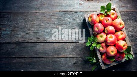 Ripe Apples In Wooden Basket On The Rustic Table Stock Photo