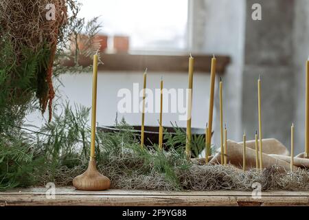 Table setting with Handmade candles on rustic old wood table and wood accessories in earth tones boho style Stock Photo