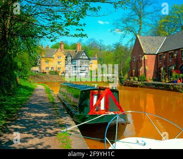 UK, England, Salford, Worsley, The Packet House, Bridgewater canal, with natural iron stained water, and canal boats Stock Photo