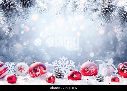 Christmas - Red Ornament On Snow With Fir Branches Stock Photo