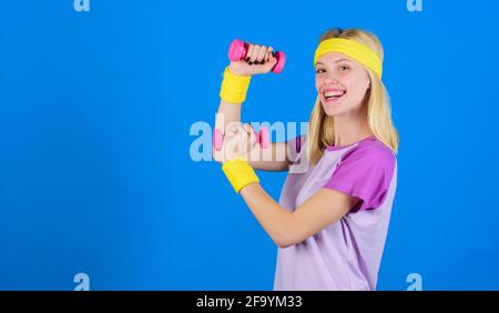 Ultimate upper body workout for women. Fitness instructor hold little dumbbell blue background. Fitness concept. Girl exercising with dumbbell Stock Photo