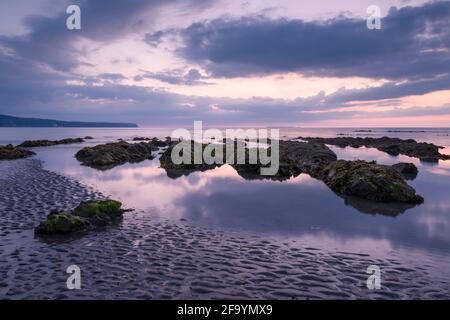 Peppercombe beach at dusk on the North Devon coast with Hartland point in the distance, England. Stock Photo