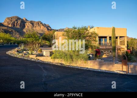 Contemporary adobe home with desert landscaping near sunset with mountain backdrop in Tucson, AZ. Stock Photo