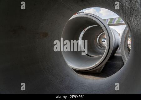 Concrete sewer pipes, stored on a construction site during sewer rehabilitation works, on the Dickswall, city centre of Mülheim an der Ruhr, NRW, Germ Stock Photo