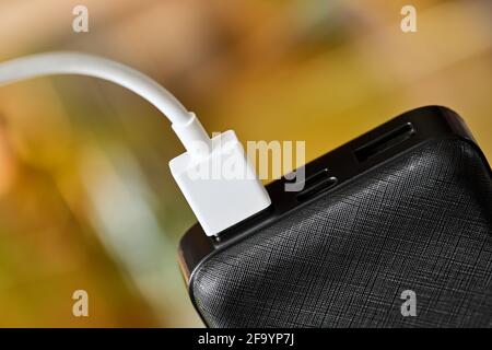 USB connector is connected to Power bank. Charging gadgets. Close-up, selective focus Stock Photo