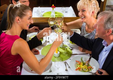 Family, mother and father with adult children and daughter or son in law –fine dining in nice restaurant or hotel Stock Photo