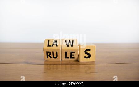 Laws or rules symbol. Turned cubes and changed the word 'rules' to 'laws'. Beautiful wooden table, white background, copy space. Business and laws or Stock Photo