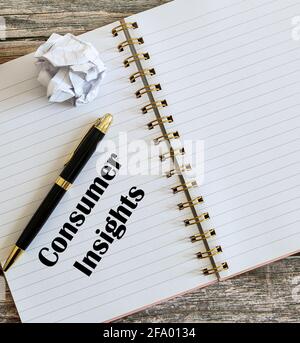 Top view of a pen with Consumer Insights written on a notebook. Stock Photo