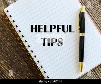 Top view of a pen with Helpful Tips written on a notebook. Stock Photo