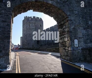 The Well Tower of Caernarfon Castle through an arch in the Town Wall Stock Photo