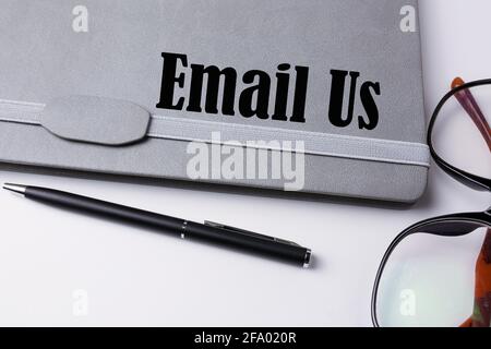 Email us written on a notebook. Stock Photo