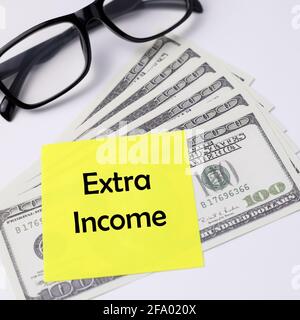 Extra income written on a yellow sticky note. Stock Photo