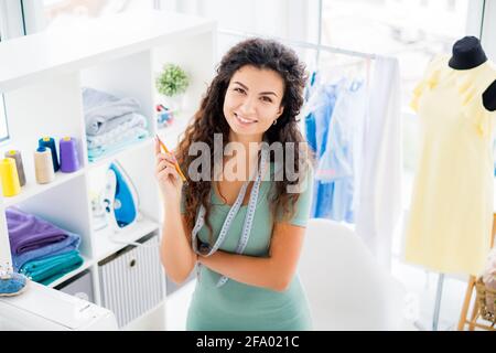 Confident sempstress in workshop with sewing equipment Stock Photo