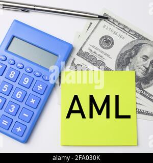 Top view of a calculator, pen and money with text AML written on yellow sticky notes Stock Photo