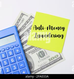 Top view of a calculator and money with text Anti-money laundering written on yellow sticky notes Stock Photo