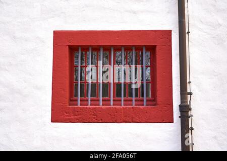 One small closed window, barred with black metal bars. Stock Photo