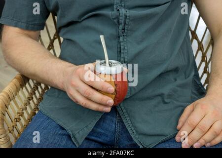 The man drinks yerba mate from a traditional dish called "matero", a herbal infusion made from leaves and stalks of Paraguay Holly, A drink with healt Stock Photo