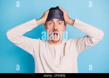 Portrait of nice worried overwhelmed brunet guy wearing eye mask news reaction isolated over bright blue color background Stock Photo
