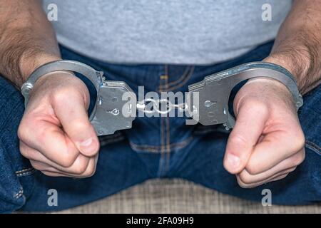 Close-up of the handcuffs on the hands of the criminal. The concept of justice Stock Photo