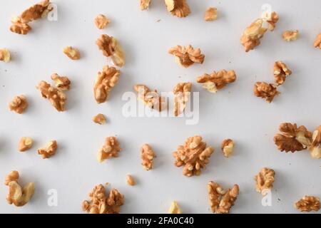 Pieces of walnuts on white table top. Top view. Horizontal composition. Stock Photo