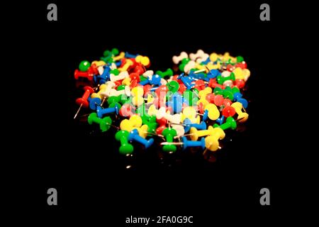 Multicolor Plastic Head Push Pins Thumbtacks isolated on black with reflections Stock Photo