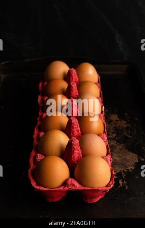 One dozen eggs, in a red egg carton Stock Photo