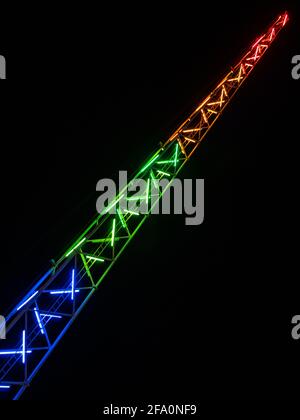 High slingshot catapult rides steel tower highlighted by colorful led lights in an amusement Luna park on the background of a black sky in Ayia Napa. Stock Photo