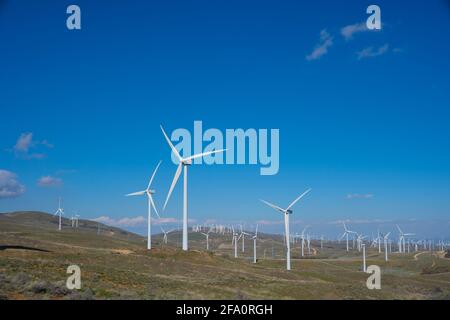 Wind turbines power nearby homes in the mountains above Los Angeles California Stock Photo