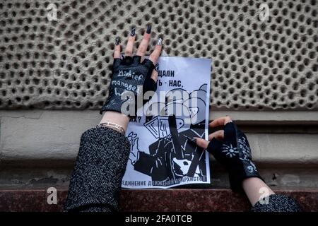 Moscow, Russia. 21st of April, 2021 A girl hangs a banner against a police brutality during a rally in support of jailed Russian opposition activist Alexei Navalny in Moscow, Russia. Navalny's team called for nationwide protests after reports about the politician's health deteriorating in prison Stock Photo