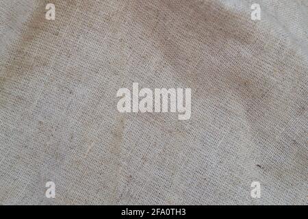 Rough linen fabric is randomly folded. Textile background Stock Photo