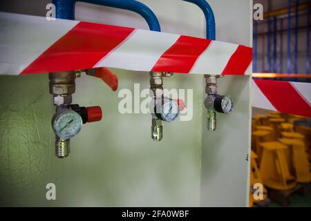 Astana (Nur-Sultan) locomotive-building plant. Modern factory workshop. Blue pipes of compressed air, plug connectors and manometers and safety tape. Stock Photo