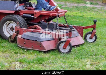 Close up of man worker cutting grass in summer with a lawn mower Stock Photo