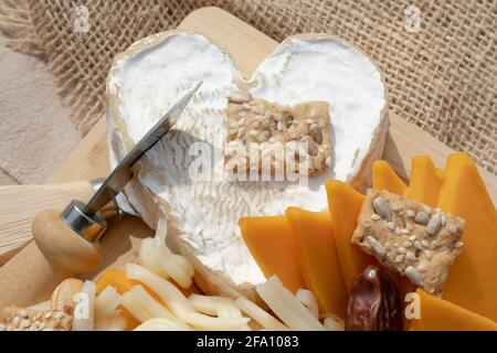 Neufchatel Heart Shaped aged Camembert Cheese on French cheeses plate in assortment from Normandy. Stock Photo