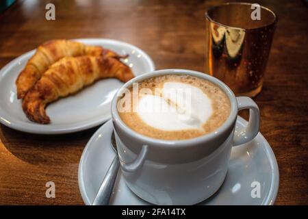 Coffee with milk with fat croissants and golden candle holders.