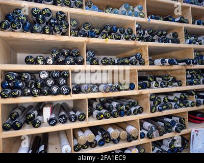 Glass pressing rods. Stack of bunch of colorful glass rods on shelf in ...