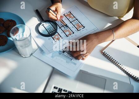 Female architect studying building plan at home Stock Photo