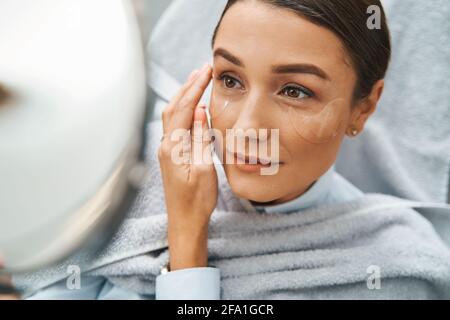 Young beauty salon customer viewing her reflection using a handglass Stock Photo