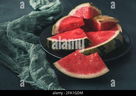 Pieces of watermelon on a black plate on green background Stock Photo