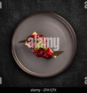 Flat lay of cheesecake with raspberry jelly on dark background Stock Photo