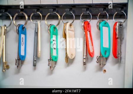 The keys to the doors with tags hang on hooks in a special drawer. Selective focus Stock Photo
