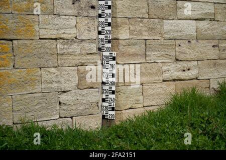 Brick wall with water measurement on Old Stone Bridge in Regensburg, Germany Stock Photo