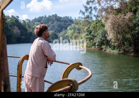 Shan state, Myanmar - January 5 2020: A local burmese man in traditional clothing day dreaming by the water from Kalaw to Inle Lake Stock Photo