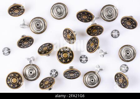 Bronze vintage buttons with metal pins on white background, jeans fashion, close up. Stock Photo
